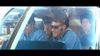 Three men in blue uniforms and sunglasses sit in an aircraft cockpit, intently focused on controls, as a fourth stands behind. The intense scene recalls the suspense of The Hot Rock (1972) DVD starring Robert Redford. Sunlight floods the windshield.
