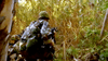Two soldiers in camouflage with rifles and backpacks move through dense foliage, evoking the intense scenes found in the Lost At War (2007) DVD.