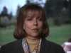 A woman in a beige turtleneck, floral scarf, and gray coat stands outdoors with a grassy background, looking emotional—evoking scenes from the "Color Me Perfect (1996) DVD.