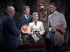 Four people in old Western attire converse in a richly decorated room with dark drapes, a floral lamp, and framed art—reminiscent of scenes from the classic film "Carson City (1952)" available on DVD.