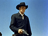 A serious-looking cowboy in black attire stands under a clear blue sky, revolver by his side—just like in Carson City (1952) on DVD.