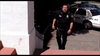 A police officer in uniform walks up steps toward a building, with a police car parked nearby—reminiscent of scenes from the Family Sins (2004) DVD.