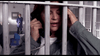 A distressed woman in a gray jacket holds a phone behind jail bars, while someone mops the floor—evoking dramatic scenes from the "Family Sins (2004) DVD.