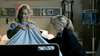 In a hospital room, a woman in a gown clutches her sheet as another comforts her—an intense scene reminiscent of true crime stories found in An Officer and a Murderer (2012) DVD.