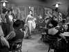 A woman in an elegant dress performs with a bouquet and whip in an old-fashioned saloon, echoing the vibrant, vintage spirit of classic cinema found in "The Broken Star (1956)" DVD.