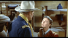 A man in a cowboy hat and uniform faces a woman in old-fashioned clothes inside a rustic room with wooden bunk beds, evoking classic scenes from the "7th Cavalry (1956) DVD.