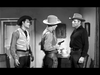 Three men in cowboy hats and western attire stand indoors as one points a gun at another while Buster Crabbe looks on. This dramatic black-and-white scene is from Gunfighters of Abilene (1960) DVD, evoking classic Old West films.