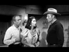 In a tense indoor scene from Gunfighters of Abilene (1960) DVD, an older man, a surprised young woman, and a cowboy-hatted man—possibly Buster Crabbe—face each other in classic black and white Old West style.