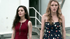 Two young women stand outside looking distressed, like they've stepped from a scene in a dinosaurs movie—one in a red zippered dress, the other in navy polka dots—just like characters from rare films such as Jurassic City (2015) DVD.