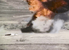 A large fiery explosion erupts in a desert, smoke billowing as seen in Warhead (1977) DVD—echoing the film's intense drama with scattered vegetation and distant hills framing the scene.