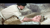 A man in military uniform kneels beside another on the ground, gripping his shoulders in concern—a dramatic moment from "Tank Force (1958) DVD," set against a WWII desert landscape with rocky hills.