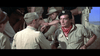 A group of men in military uniforms gather in a truck, echoing scenes from classic war movies like Tank Force (1958) DVD. One, in a black beret and red scarf, speaks to another with his back to the camera, adding to the serious atmosphere.