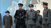 Several men in Nazi uniforms stand before a large map of Europe, with two decorated officers in front and a man in a suit to the left. Find rare films on DVD like this classic scene from Massacre at Noon (1975) DVD.