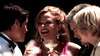 Four people dressed formally laugh together outdoors, holding glasses of white wine or champagne. Flowers enhance the celebratory mood, reminiscent of scenes from the Too Late To Say Goodbye (2009) DVD.