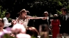 A bride and groom hold hands, dancing outdoors at their wedding reception, surrounded by guests and floral decor as sunlight filters through the trees—evoking a scene from "Too Late To Say Goodbye (2009)" DVD.