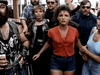 A group resembling a military action movie scene, with a woman in red and denim shorts at the center, stands surrounded by biker-styled figures—perfectly capturing the intense vibe of Snake Eater (1989) DVD.