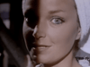 A woman with light eyes and a towel wrapped around her head gazes at the camera, half her face in shadow—a scene echoing the suspenseful vibe of Don’t Look in the Basement (1973) on DVD.