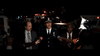 A police officer in uniform gives a statement to reporters at night with emergency vehicles flashing nearby—evoking the suspenseful atmosphere of "The Black Phone (2021)" DVD.