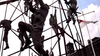 Several people in military uniforms climb a tall metal structure outdoors under a partly cloudy sky, with a flag waving in the background—evoking scenes from classic war films like Attack on the Iron Coast (1968) DVD.