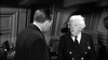 A suited man faces Miss Marple, with curly white hair and a double-breasted uniform, in a wood-paneled room—evoking classic scenes from the Murder Ahoy (1964) DVD.
