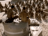 Two soldiers sit on a military tank before a crowd on sandy ground—a scene echoing vintage films. Ideal for collectors or fans seeking the Sahara (1995) DVD or other rare movie DVDs.