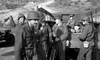 A group of soldiers in uniform gather by a truck amid rugged hills, evoking vintage war scenes—just like those in the classic film "War Hunt (1962)," now available on DVD.