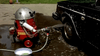 A red, retro-styled robot sprays water on a soapy car's wheel beside a metal bowl of suds—capturing playful nostalgia just like in "And You Thought Your Parents Were Weird (1991)" on DVD.