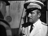 A man in a white uniform and cap, resembling Humphrey Bogart in Passage to Marseille, stands outdoors facing someone else; a ship or industrial setting is behind them. (Product: Passage to Marseille (1944) DVD).