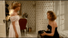 A young woman in a white off-the-shoulder dress faces an older woman in a black strapless dress, seated and holding black shoes, evoking a scene from the movie “Chances Are” (available on DVD), set in a warmly lit, floral-wallpapered room.