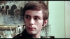 A young man with short brown hair in a dark green jacket glances aside in a room with a painting and teapot—capturing the classic film atmosphere of Dead of Night (1974) DVD.
