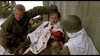 In "A Midnight Clear (1992)" DVD, two soldiers in the snowy Ardennes forest tend to a wounded comrade with a bloodied arm as he looks up anxiously while the other inspects his injury against a wall.