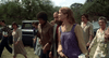 A group of men and women dressed in 1970s fashion, reminiscent of Ellen Burstyn's style in "Resurrection," walk outdoors by trees and parked cars. Product: Resurrection (1980) DVD.