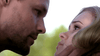 A close-up of a man holding a woman’s face as they lock serious gazes, set against a blurred green background—capturing the intense mood of rare true crime movies like Blue-eyed Butcher (2012) on DVD.