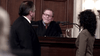 A judge with glasses and a black robe sits at the bench, talking to a man and woman in court—reminiscent of scenes from "Blue-eyed Butcher (2012)" on DVD, featuring courtroom drama with a microphone and glass pitcher on the bench.