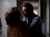 A man forcefully grabs a woman by the shoulders in a dimly lit room near a doorway—a tense moment from Tall Dark and Deadly DVD (1995), as she leans backward, echoing classic movie confrontations.