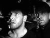 Two men look anxiously upward in a shadowy setting, their tense faces lit dramatically, capturing the suspenseful World War II atmosphere of Above Us The Waves (1955) DVD.