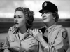 Two women in military uniforms stand close outdoors; one looks ahead with concern, while the other, in a cap, rests her hands supportively on her shoulders. The black-and-white scene recalls "The Wild Blue Yonder (1951) DVD.