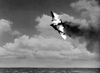 A plane engulfed in flames nosedives toward the ocean, thick smoke trailing behind—a dramatic scene reminiscent of classic films like "A Guy Named Joe (1943)" on DVD, with scattered clouds in the sky.