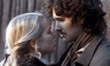 A blonde woman and a man with curly brown hair stand close, gazing into each other's eyes with serious expressions, evoking an intimate moment from "The Ugly Stepsister" DVD. Both are dressed in period-style clothing.