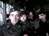 A group of soldiers in dark uniforms sit together in a military vehicle, their serious faces recalling classic WWII espionage films like Decision Before Dawn (1951) on DVD.
