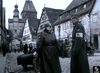 Two soldiers converse on a cobblestone street with timber-framed buildings and a clock tower, capturing the tense WWII espionage mood of Decision Before Dawn (1951) DVD.
