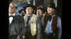 A group of men in Old West costumes, including a sheriff with a star badge and cowboy hats, stand together indoors—evoking scenes from classic Westerns like "Silver Lode (1954)" on DVD.