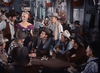Men in cowboy hats gather around a saloon table, while a woman in a purple dress stands nearby amid classic decor—evoking the suspense and style of the Silver Lode (1954) DVD.