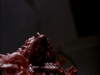 Close-up of a dark, shiny, irregular organic mass reminiscent of sci-fi horror, evoking the eerie visuals seen in rare movies like Dead Space (1991) DVD.