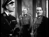 Three men in Nazi uniforms converse in an ornate room in this black-and-white scene from Seven Thunders (1957) DVD, focusing on a tense moment with a British POW in the foreground.