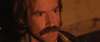 A man with light brown hair and a thick mustache stares intensely ahead on the cover of The Editor (2014) DVD, his green eyes and rugged features highlighted by warm light, capturing the film's giallo horror-comedy vibe.