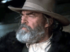 A man with a thick gray beard and mustache wears a wide-brimmed hat and dark coat, gazing intently. His rugged, serious look evokes classic characters like those in the rare Winds of Autumn (1976) DVD, with a blurred background highlighting him.