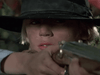 A close-up of a focused person in a wide-brimmed black hat aiming a rifle, with tears on their cheek—ideal for fans seeking rare or classic films like Winds of Autumn (1976) on DVD.