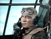 A scene from Fighter Attack (1953) DVD: A WWII pilot in goggles, headset, and flight suit sits in the cockpit, gazing out large windows at the sky—a moment evoking vintage cinema.