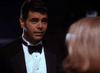 A man in a black tuxedo faces a blonde-haired woman from behind in a low-lit, nighttime scene that echoes moments from classic films like "Best Friends for Life (1998)" DVD, cherished by collectors.